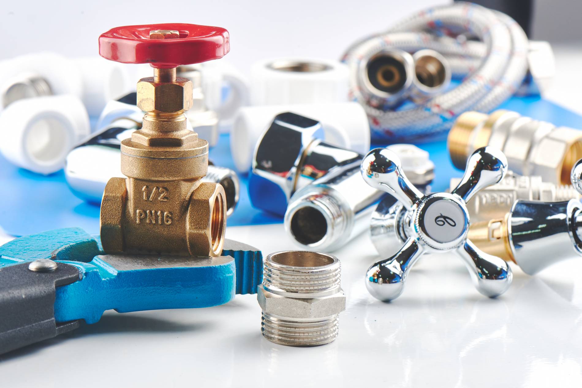 Plumbing parts, accessories and tools on a blue white backgroundÿÛ